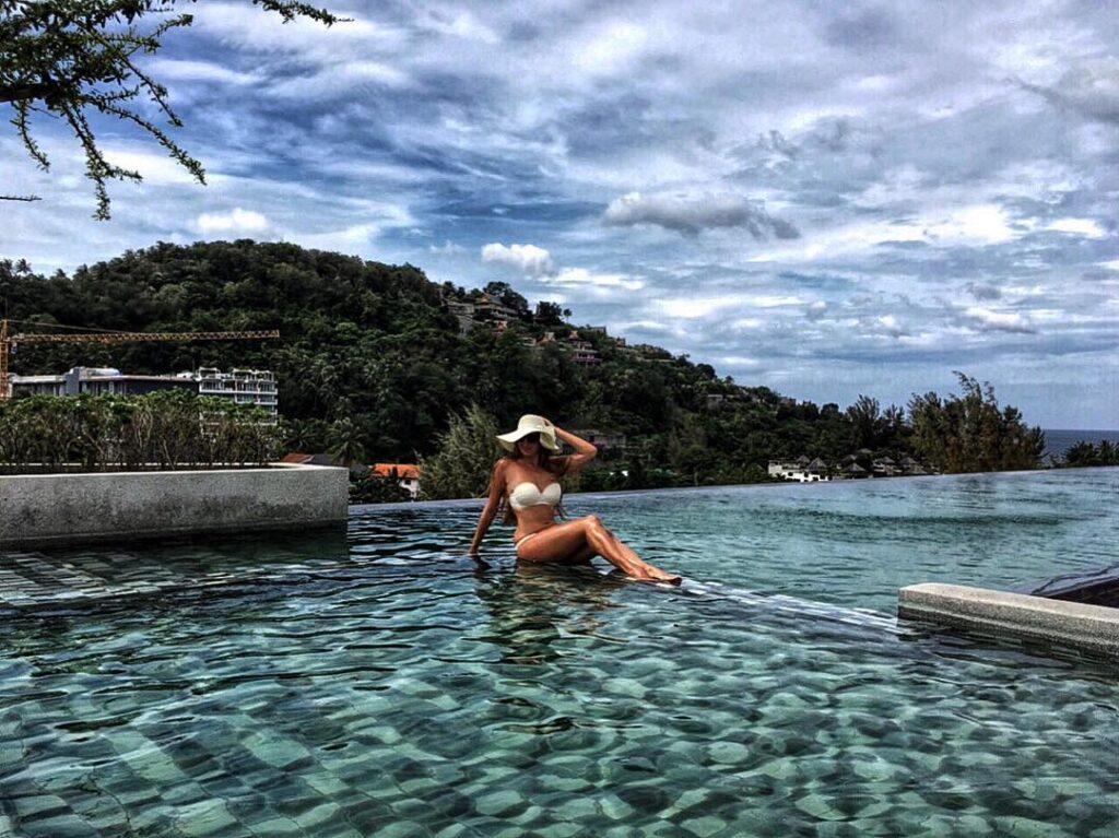 Guest relaxing in the rooftop infinity pool, 6th Avenue Surin