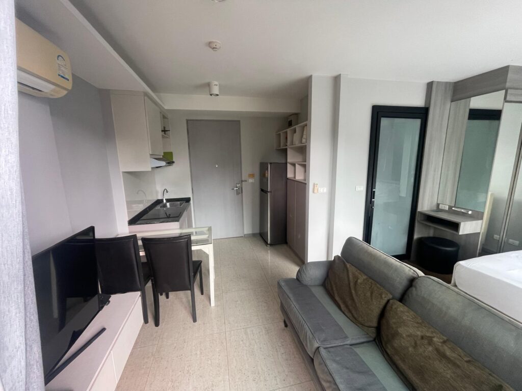 IMG-20250307-6Ave-321-7 Studio living area with sofa and TV, condo for sale in Surin